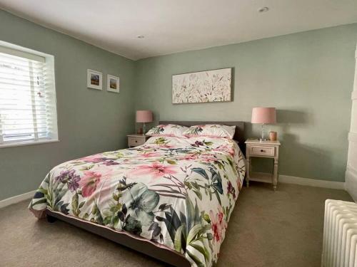 阿伦德尔Quaint Cottage in the heart of Arundel的一间卧室配有一张带花卉床罩的床