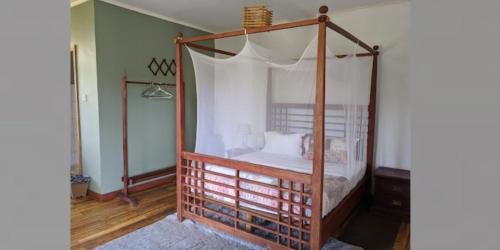 利隆圭Sunrise Motel的卧室配有带白色床单的天蓬床