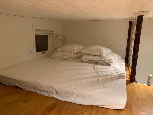 VästerhaningeFullt utrustat Minihus på landet的一张带白色床单和枕头的床
