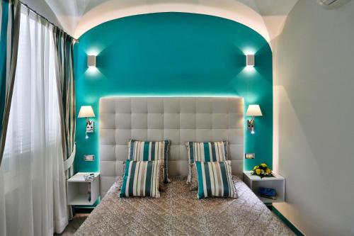 阿马尔菲Amalfi Apartments Design centro storico的一间卧室配有一张蓝色墙壁的床