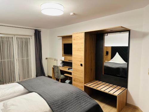 Rodalben绿色花环博德餐厅酒店的一间卧室配有一张床和一张书桌