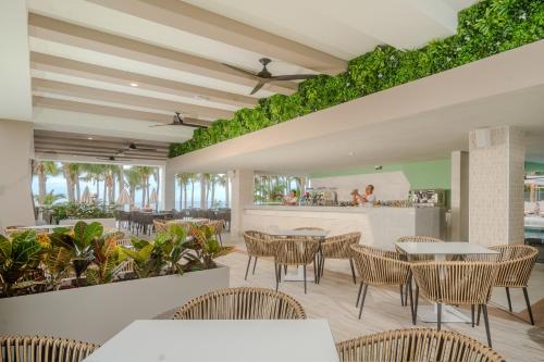 新巴利亚塔Riu Palace Pacifico - All Inclusive - Adults Only的一间带桌椅的餐厅和一间酒吧