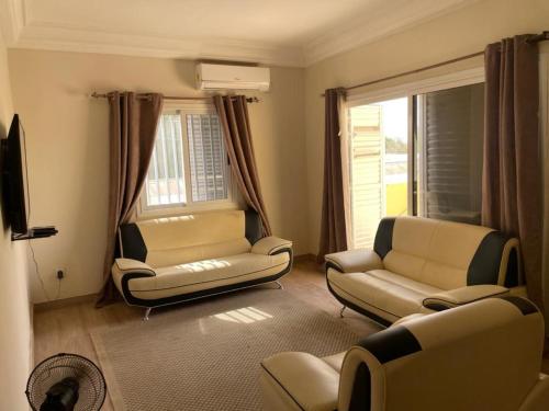 FatickSuperbe 2pieces avec climatisation的带沙发和椅子的客厅以及电视