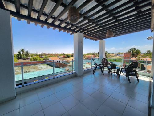 圣阿马鲁Eco House Gaivota - Cond Ville Portal das Dunas的阳台享有泳池和椅子的景致。
