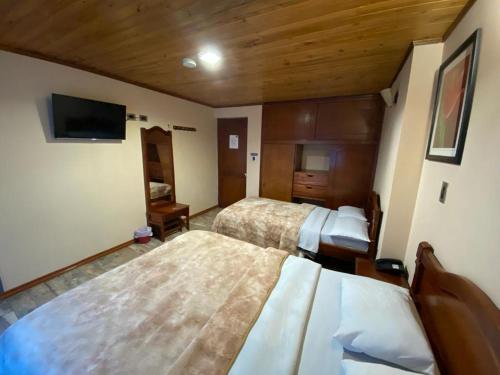 帕斯托Hotel Buenaventura的酒店客房设有两张床和一台平面电视。