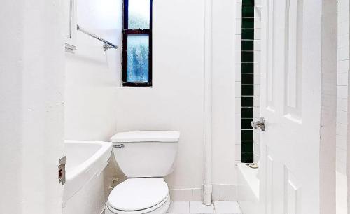纽约spaciou 1 Bedroom apartment in NYC!的白色的浴室设有卫生间和窗户。