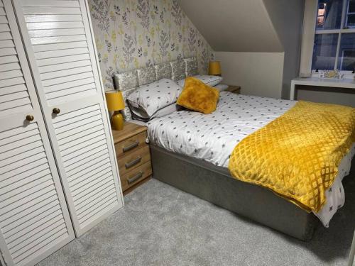 蒙特罗斯Harris Apartment的一间卧室配有一张黄色毯子床
