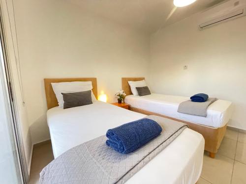 阿依纳帕Aurora Holiday Apartment - Ayia Napa的小房间设有两张床,上面有蓝色的毛巾