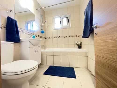 阿依纳帕Aurora Holiday Apartment - Ayia Napa的浴室配有卫生间、浴缸和水槽。