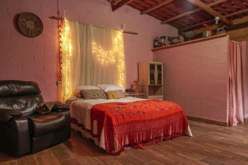 SalcoatitánCabañas Gonzalez的一间卧室配有一张带红色毯子和椅子的床