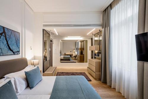 布拉格BoHo Prague Hotel - Small Luxury Hotels的一间卧室设有一张床和一间客厅。