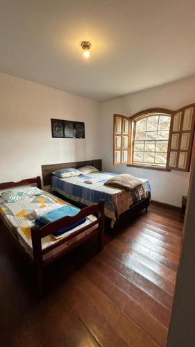 欧鲁普雷图Hostel do Mirante的一间卧室设有两张床和窗户。