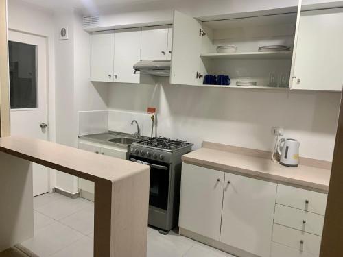 奥索尔诺Departamento nuevo con perfecta ubicación的厨房配有白色橱柜和炉灶烤箱。
