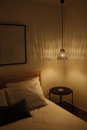 丰沙尔CASA15 Guesthouse Funchal的一间卧室配有一张床和一张带台灯的桌子