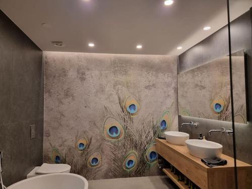 莫斯特拉纳Comfy mountain nest的浴室设有两个水槽,墙上挂着孔雀羽毛