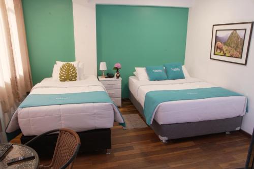 库斯科MATARA GREENS HOTEL的蓝色和白色的客房内的两张床
