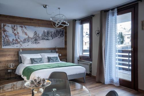 帕苏德尔托纳莱Diamante ampio monolocale stile chalet alpino的一间卧室配有一张床和一张玻璃桌