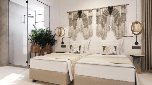 Megálon ChoríonUtopia Luxury Resort的白色墙壁客房的两张床