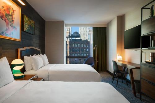纽约Renaissance New York Chelsea Hotel的酒店客房配有两张床和一张书桌