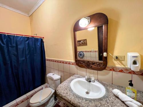 科马亚瓜Hotel Caxa Real的一间带水槽、卫生间和镜子的浴室