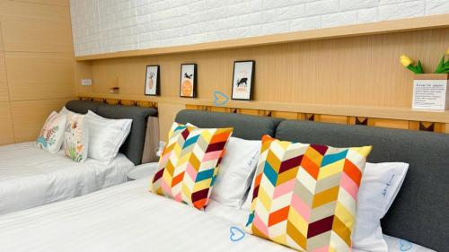 头城丘海之境的客房配有两张带色彩缤纷枕头的床。