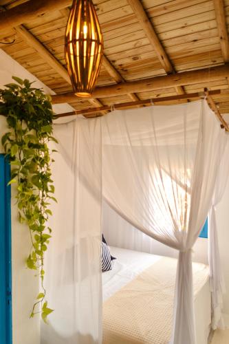 托兰克索Villa Joá - Casa的一间卧室配有一张带挂花架的天蓬床