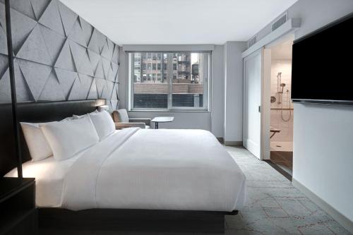 纽约SpringHill Suites by Marriott New York Midtown Manhattan/Park Ave的卧室配有一张白色大床和电视。