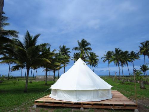 ZapotalGlamping La Isla Bonita (Isla Portete, Ecuador)的棕榈树木平台上的白色帐篷