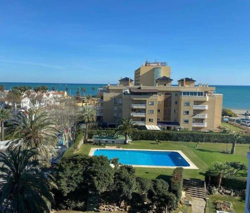 马拉加Espectacular apartamento junto al mar, con piscina en Málaga的一座带游泳池的度假村,位于一座建筑前