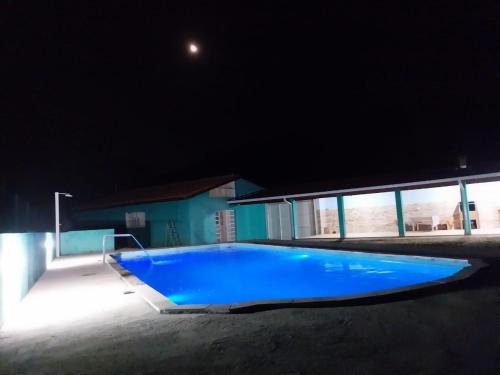 若阿诺波利斯Casa de campo Maciel的夜间大型蓝色游泳池