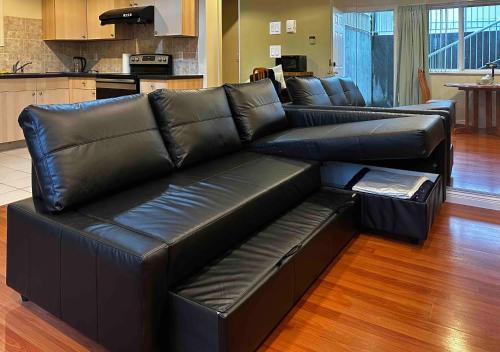 温哥华SixPine Suite的客厅里一张黑色皮沙发