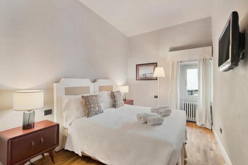 佛罗伦萨Tornabuoni Living - Luxury Apartments Collection的卧室配有一张白色大床和电视。