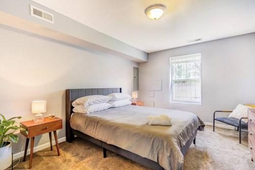 华盛顿Spacious Suite in Deanwood + Free Parking的一间卧室配有一张床、一张桌子和一个窗户。
