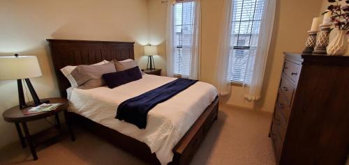 史密斯堡Old Fort Loft King & Queen suites nearest accomodation to Marshals Museum power your EV for free!的一间卧室配有一张床、梳妆台和窗户。