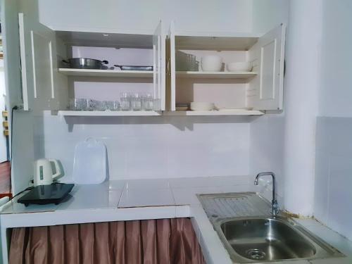 高兰Star house的厨房配有白色橱柜和水槽