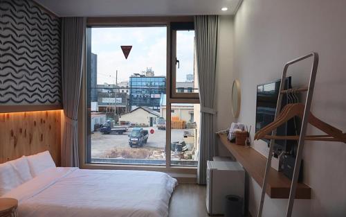 木浦市38th Street Guesthouse的一间卧室设有一张床和一个大窗户