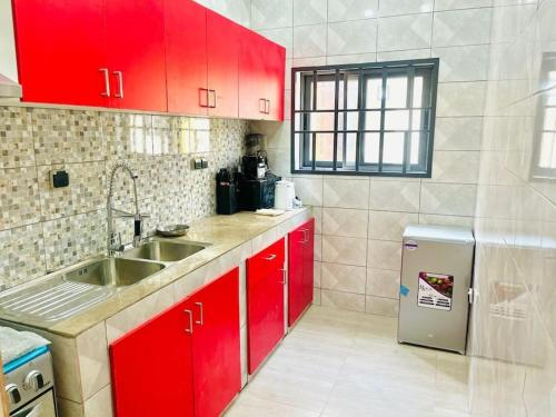KpaliméLes 9 Plurielles T 2 KPALIME KOUMA KONDA的一间带红色橱柜和水槽的厨房