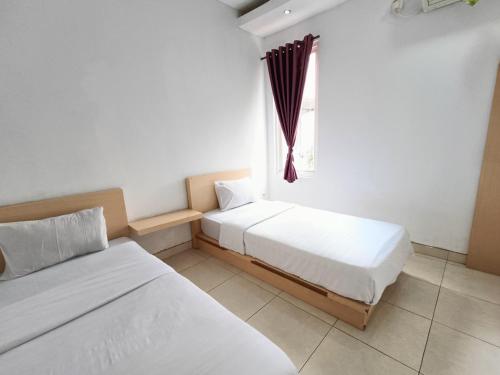 PuunggolakaUrbanview Hotel B Liv Kendari的带窗户的客房内的两张床