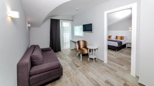 马尔马里斯Motto Premium Hotel&Spa的带沙发的客厅和卧室