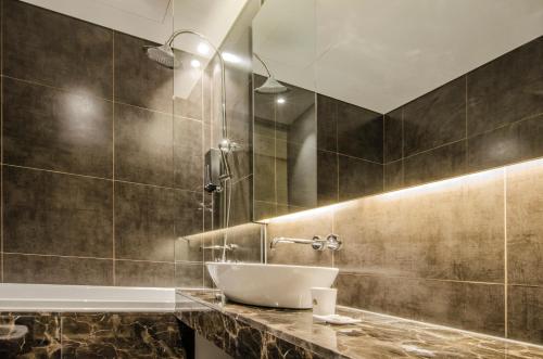 首尔Hotel The Designers Premier Kondae的一间带水槽和浴缸的浴室