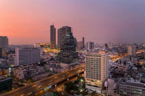 曼谷Hilton Garden Inn Bangkok Silom的享有夜间城市景观和建筑