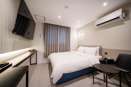 首尔Baron De Hotel的酒店客房设有一张白色大床和一张书桌