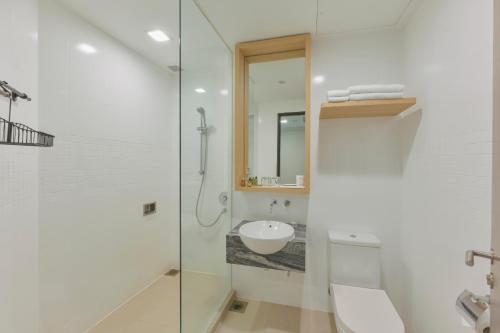 新加坡Changi Cove的白色的浴室设有水槽和淋浴。
