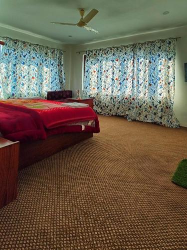 帕哈尔加姆Tip Top Pahalgam的一间卧室配有一张带蓝色窗帘的大床