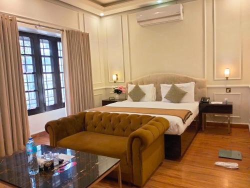 伊斯兰堡Riviera Courtyard Guest House Islamabad的酒店客房,配有床和沙发