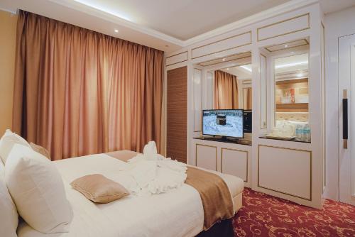 班达亚齐Portola Grand Arabia Hotel的酒店客房,配有床和电视