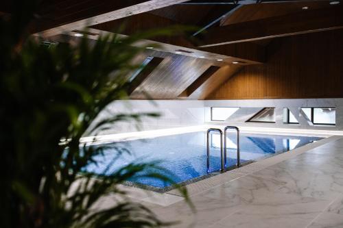 UngureniPodina Resort Hotel & Spa的一座带天花板的建筑中的游泳池