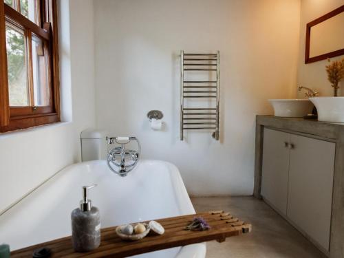 斯坦福Springfontein Wine Estate的带浴缸和两个盥洗盆的浴室
