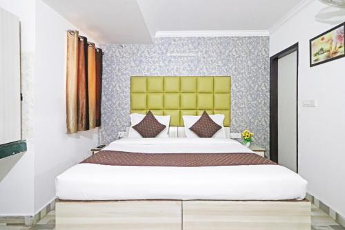 新德里Hotel Clink Stay Near Delhi IGI Airport的一间卧室配有一张带黄色床头板的大床