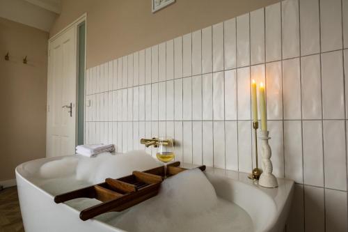 羊角村B&B Giethoorn的浴室内配有带蜡烛的浴缸。